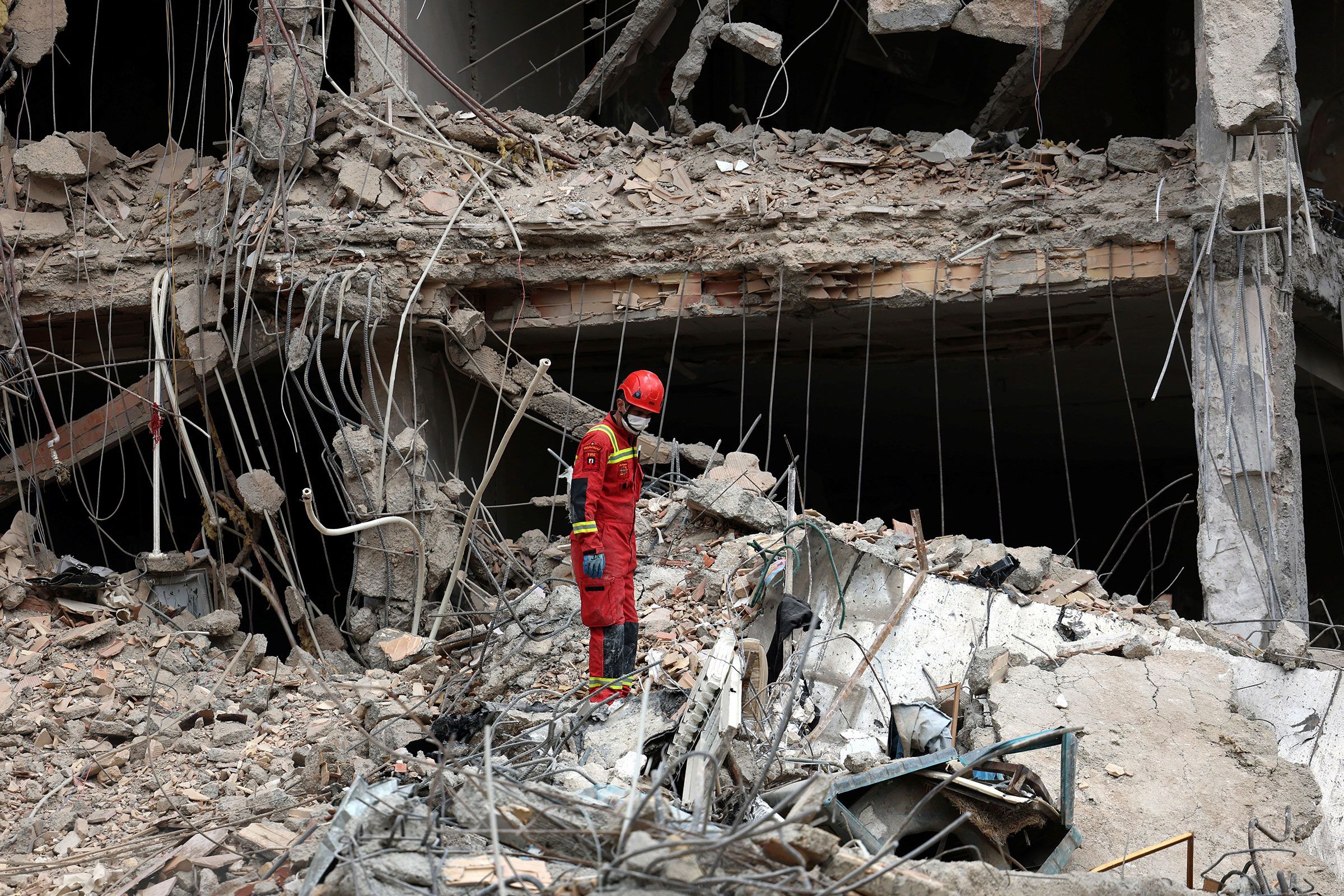 <i>AFP/Getty Images via CNN Newsource</i><br/>An Iranian firefighter walks on the rubble of a destroyed residential building in Tehran