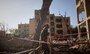 A man looks at residential buildings damaged by an Iranian missile strike in Arad