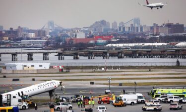 Officials inspect the wreckage of an Air Canada Express regional jet on Wednesday at LaGuardia Airport in New York.