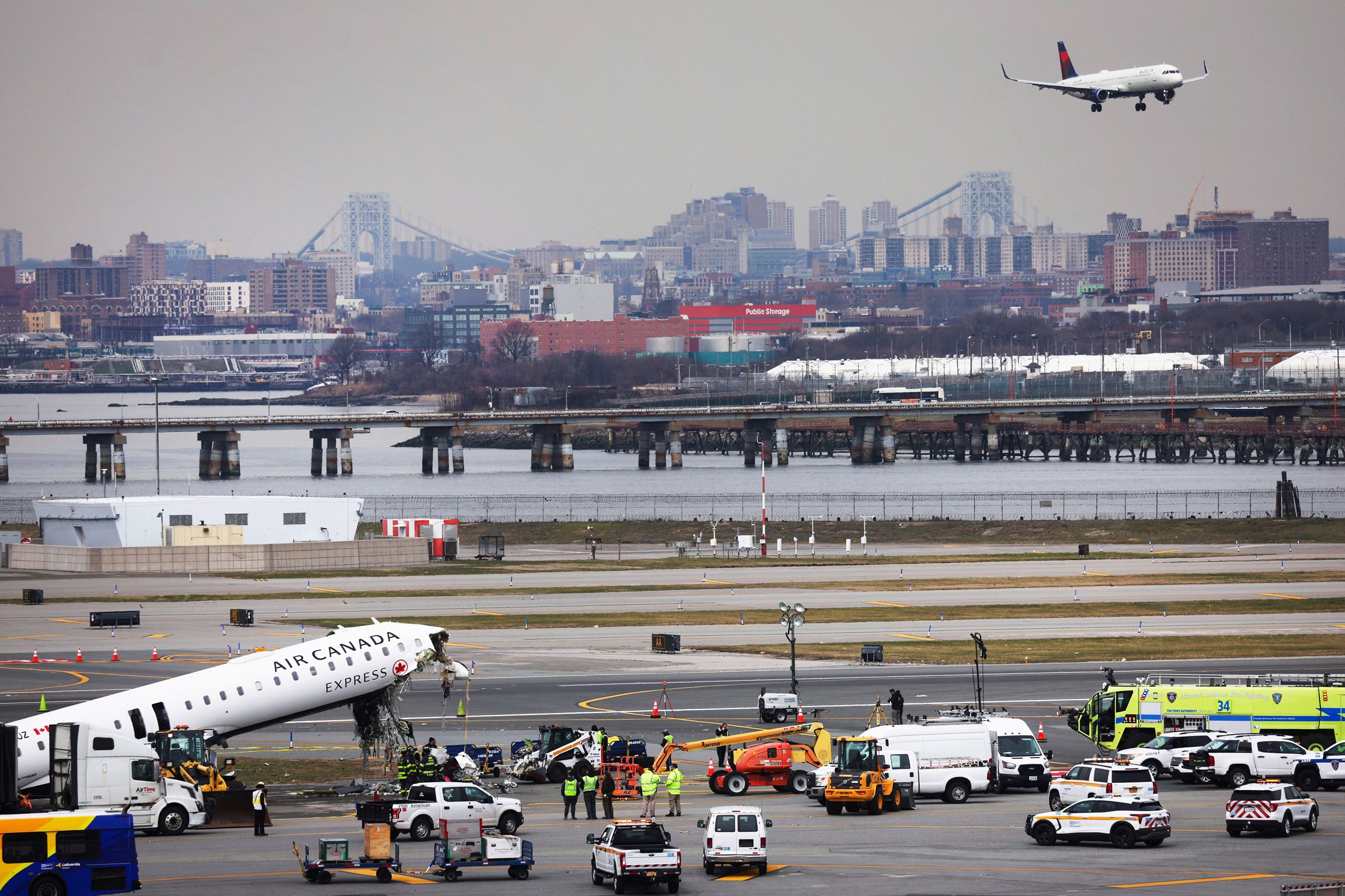 <i>Yuki Iwamura/AP via CNN Newsource</i><br/>Officials inspect the wreckage of an Air Canada Express regional jet on Wednesday at LaGuardia Airport in New York.