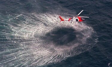 Members of the Kennedy and Bessette families embrace at the stern of the Coast Guard ship Sanibel as they prepare to travel to the USS Briscoe on July 22