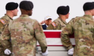 A Lebanese woman stands inside the ruins of her home