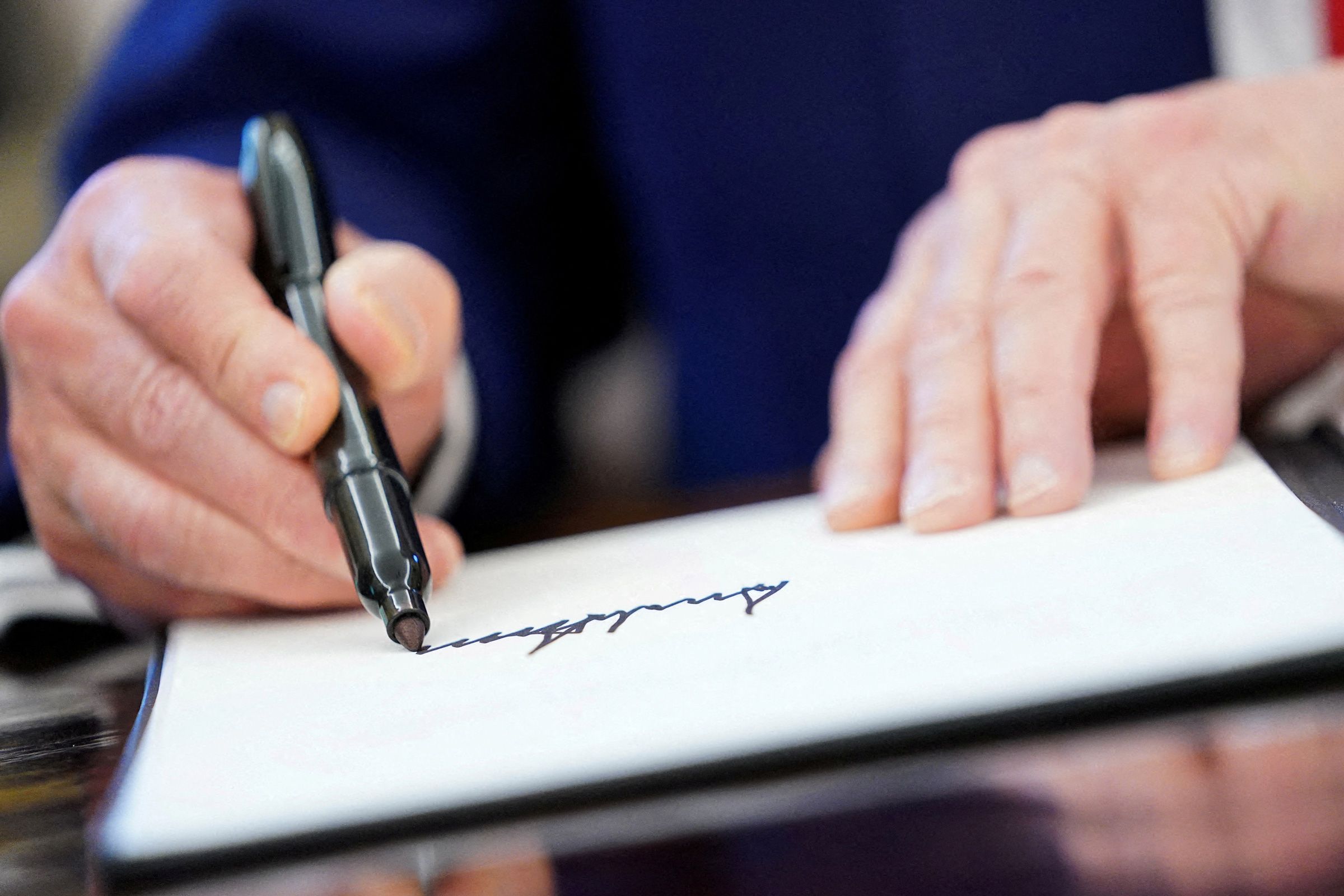 <i>Nathan Howard/Reuters/File via CNN Newsource</i><br/>President Donald Trump writes his signature