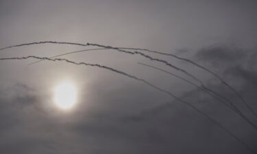 Palestinians gather around the wreckage of an Iranian missile that landed in the West Bank village of Kifl Haris Tuesday
