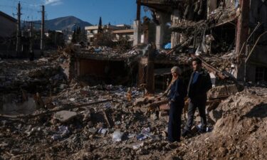 An Israeli soldier uses a torch to inspect the damage after Iranian missile barrages struck Dimona