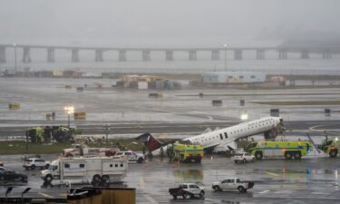 An Air Canada jet and Port Authority fire truck sit on the runway at LaGuardia Airport
