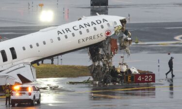 An Air Canada Express CRJ-900 sits on the runway after colliding with a Port Authority fire truck (L) at LaGuardia Airport in New York.