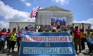 People hold a banner as they participate in a protest outside the US Supreme Court over President Donald Trump's move to end birthright citizenship on May 15