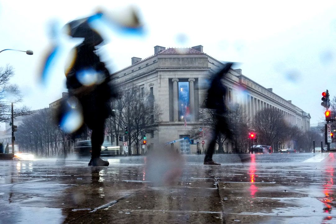 <i>Ken Cedeno/Reuters/File via CNN Newsource</i><br/>People walk in heavy rain near the Department of Justice building in Washington