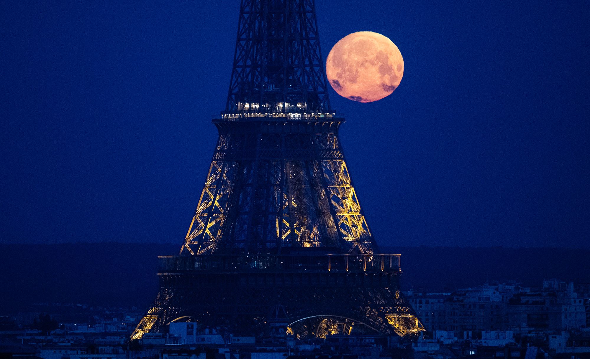 <i>Stefano Rellandini/AFP/Getty Images via CNN Newsource</i><br/>The full pink moon graces the evening sky in Paris in April 2024.