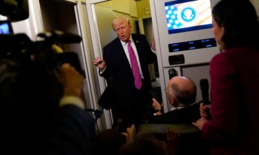 President Donald Trump talks to the press aboard Air Force One en route to Joint Base Andrews