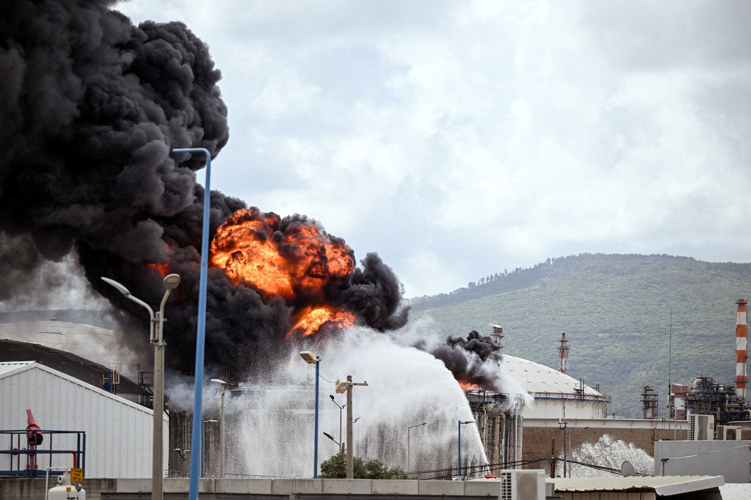 <i>Rami Shlush/Reuters via CNN Newsource</i><br/>A blaze after Israel's Fire and Rescue Service said that an industrial building and a fuel tanker at Israel's Oil Refineries were hit by debris from an intercepted Iranian missile