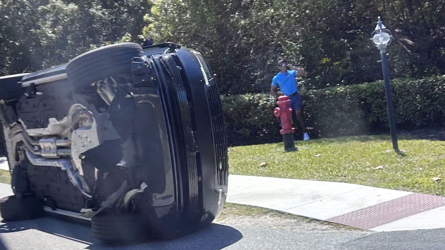 <i>Jason Oteri/AP via CNN Newsource</i><br/>Golfer Tiger Woods stands by his overturned vehicle in Jupiter Island