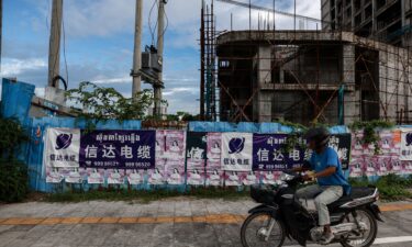 A motorbike rides past an unfinished building in Sihanoukville