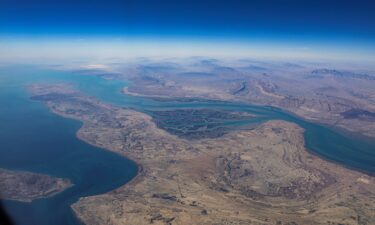 Workers clean solar panels at a solar power plant in Surajpur