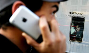 A man uses an Apple iPhone outside the Apple store on Regent Street on device's UK launch day