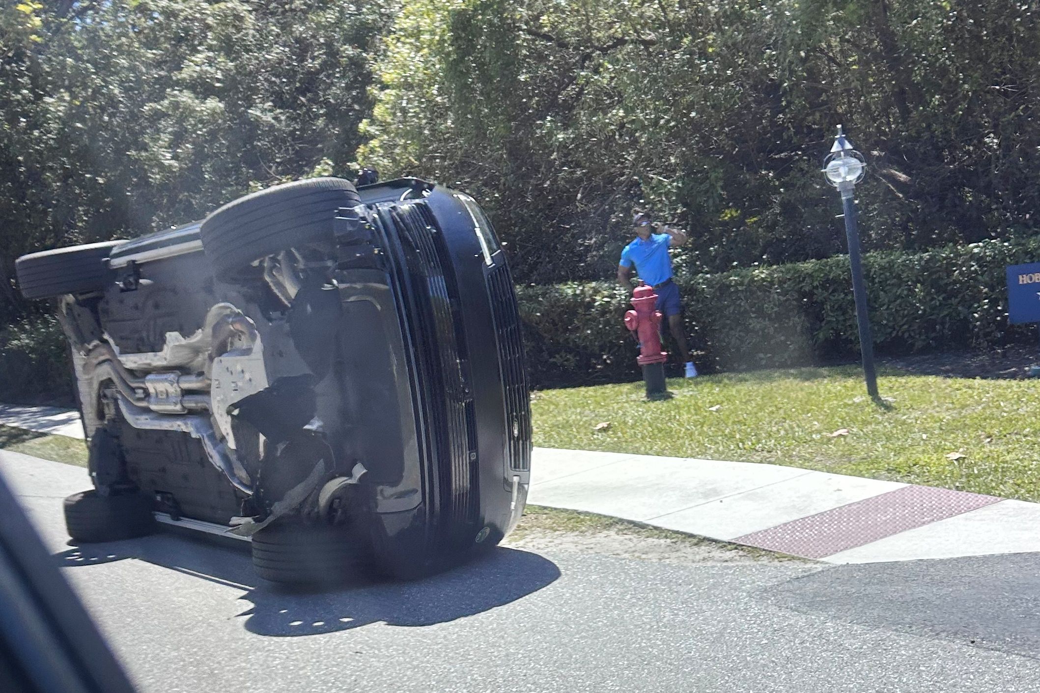 <i>Jason Oteri/AP via CNN Newsource</i><br/>Golfer Tiger Woods stands by his overturned vehicle in Jupiter Island