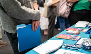 A jobseeker holds a folder while speaking with a recruiter during the WorkSource North Seattle Career Fair on February 10