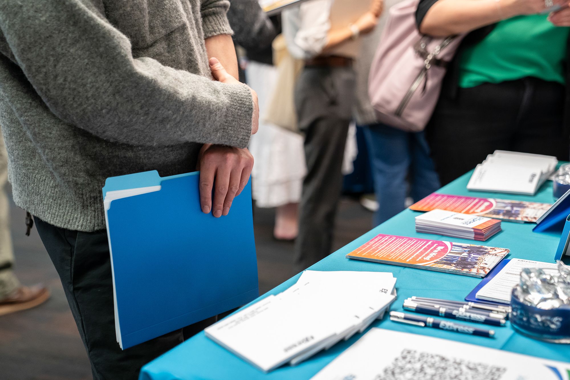 <i>David Ryder/Bloomberg/Getty Images via CNN Newsource</i><br/>A jobseeker holds a folder while speaking with a recruiter during the WorkSource North Seattle Career Fair on February 10