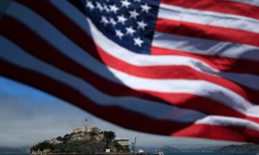An American flag flies on a boat leaving Alcatraz Island in San Francisco