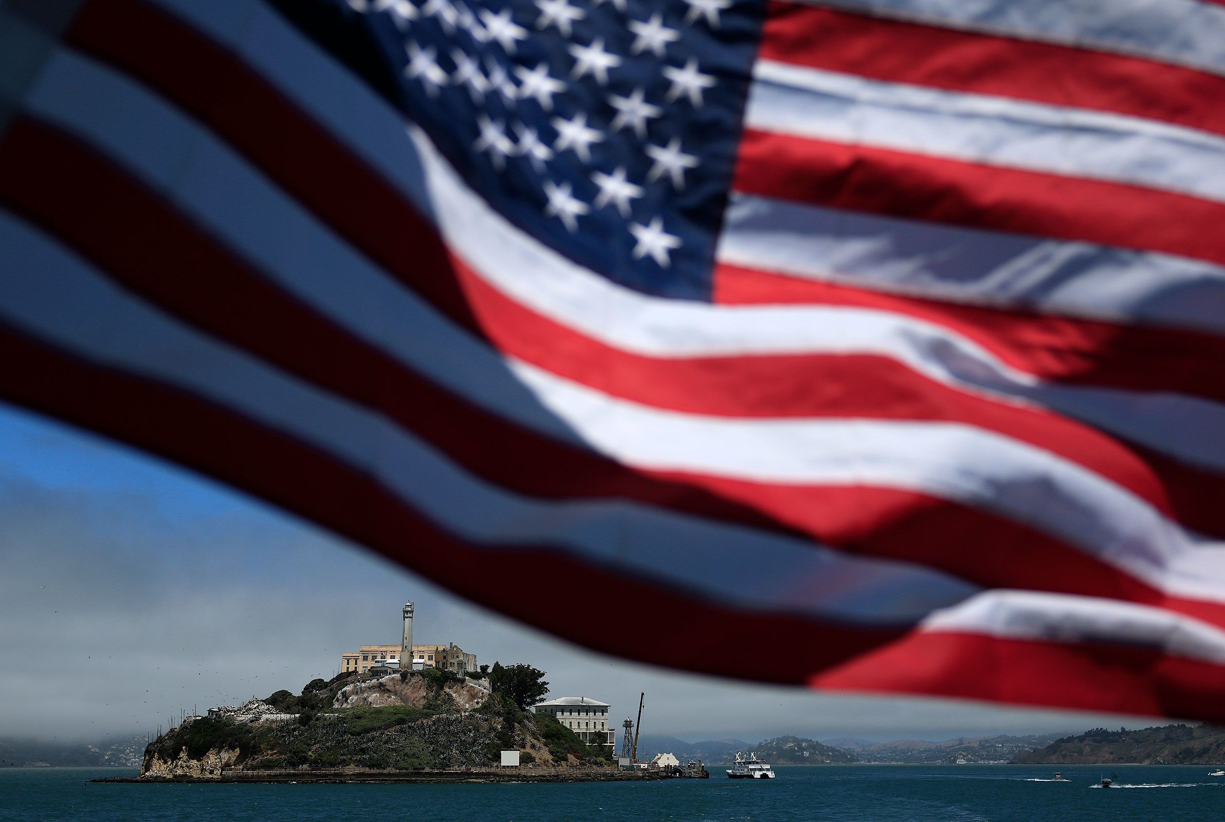 <i>Justin Sullivan/Getty Images/File via CNN Newsource</i><br/>An American flag flies on a boat leaving Alcatraz Island in San Francisco