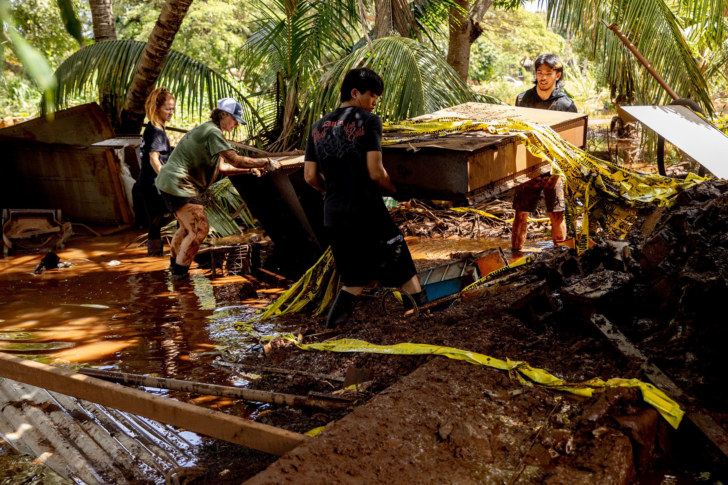 <i>Stephen Lam/San Francisco Chronicle/Getty Images via CNN Newsource</i><br/>Volunteers carry debris from a home impacted by flooding in Haleiwa