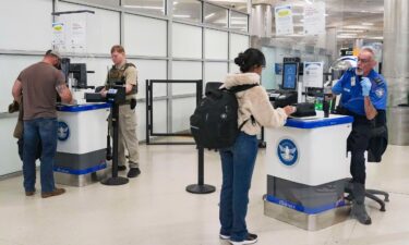 An ICE agent and TSA member check IDs at a security counter at Hartsfield-Jackson Atlanta International Airport on March 28.