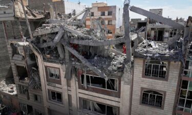 First responders inspect a residential building hit in an earlier US-Israeli strike in Tehran