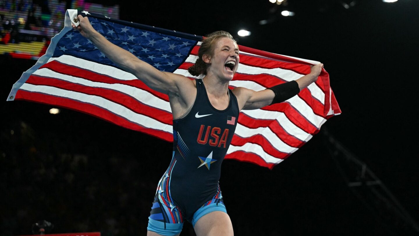 TOPSHOT - US' Sarah Ann Hildebrandt celebrates her national flag after her win over Cuba's Yusneylis Guzman Lopez in their women's freestyle 50kg wrestling final match at the Champ-de-Mars Arena during the Paris 2024 Olympic Games
