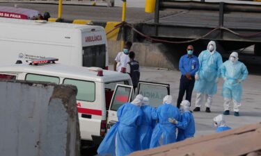 A person in a hazmat suit (2R) is escorted to a ambulance from a medical aircraft allegedly carrying some of the passengers from the cruise ship MV Hondius believed to be infected with hantavirus