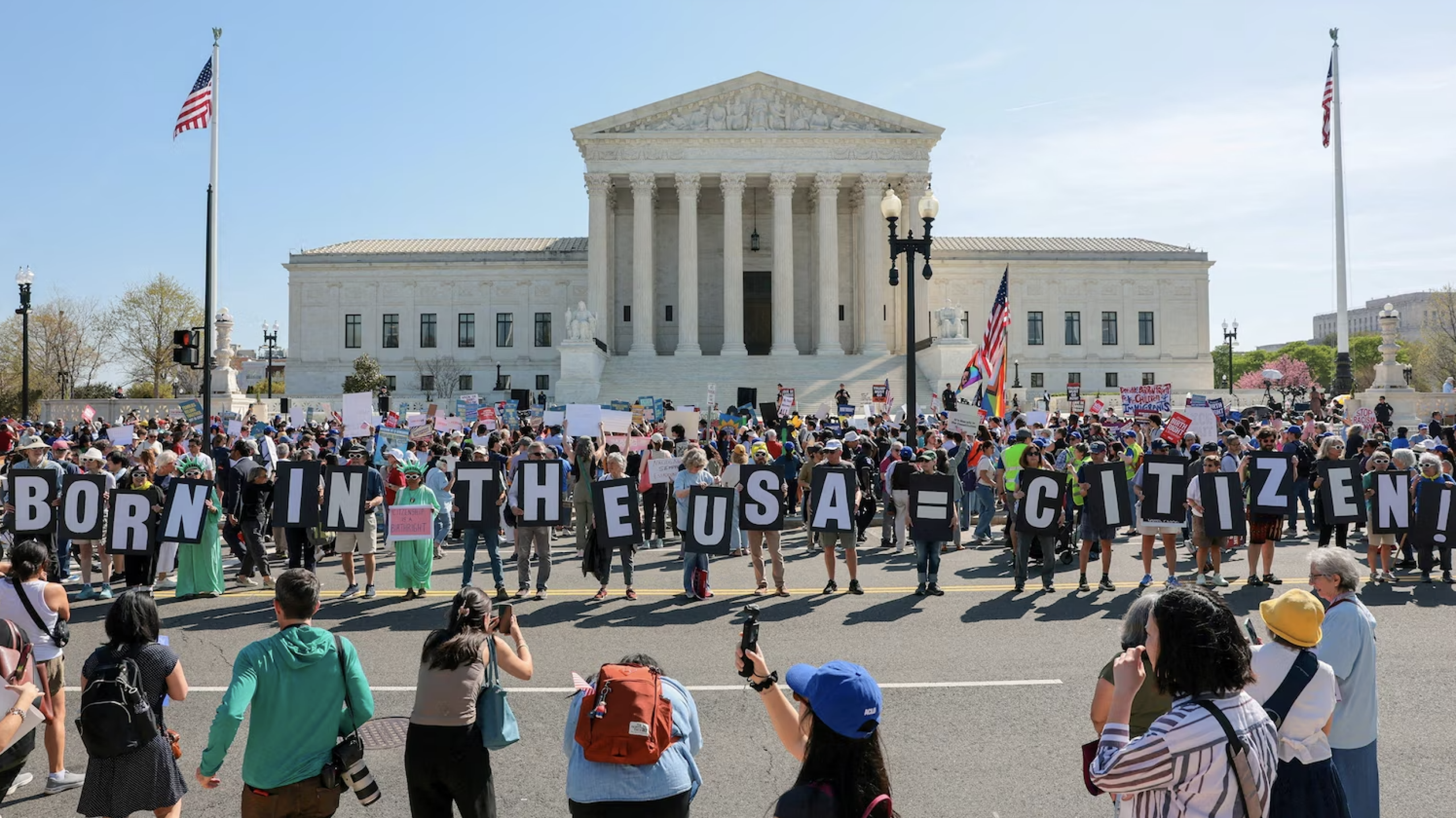 Demonstrators hold letters making up the slogan 