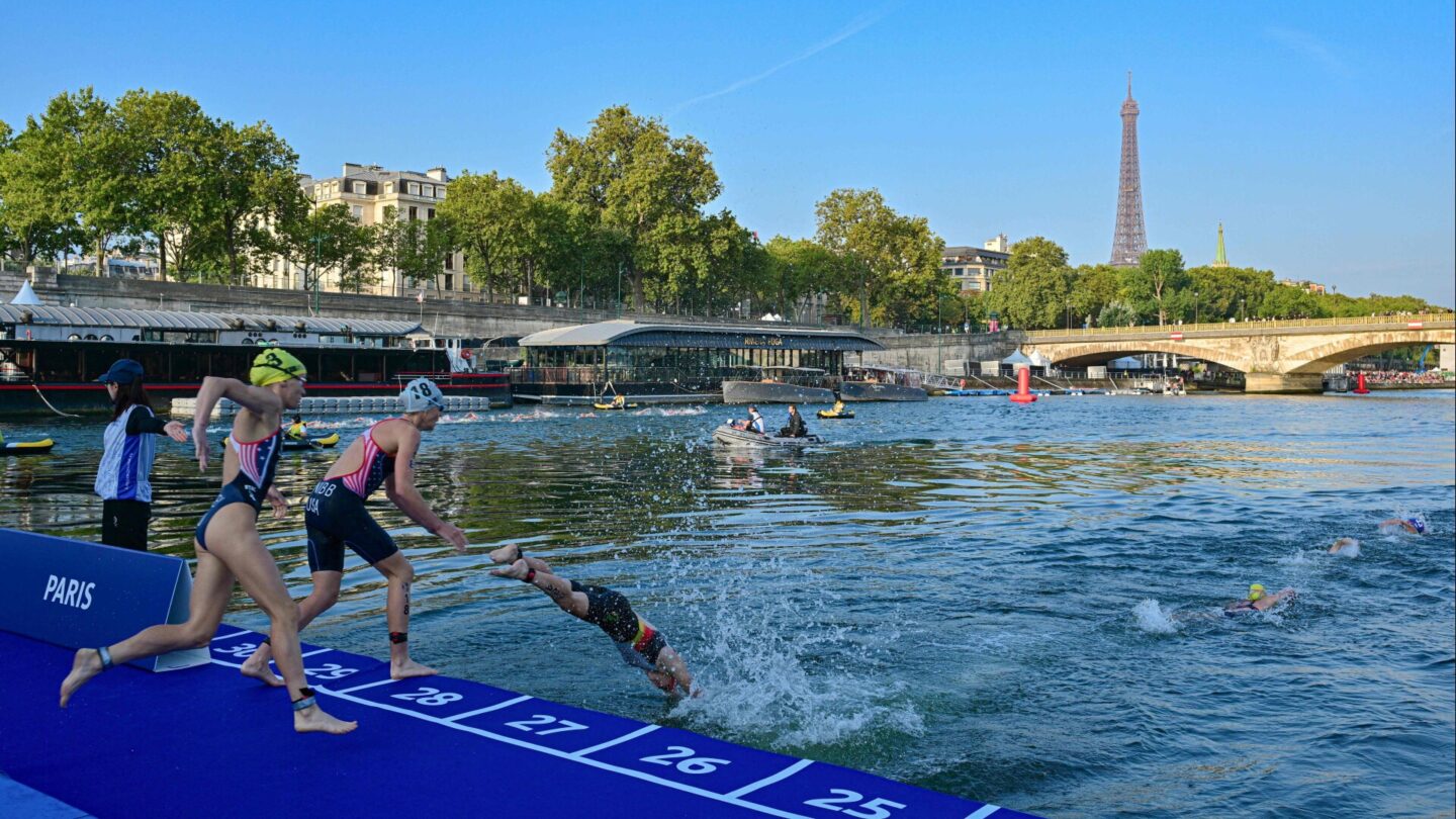 Triathlon athletes dive in the Seine river with The Eiffel Tower in the background during a Test Event for the women's triathlon for the upcoming 2024 Olympic Games in Paris