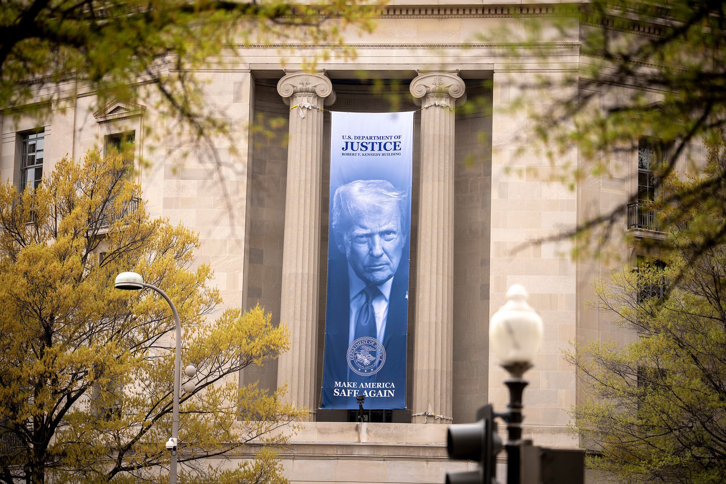 <i>Andrew Harnik/Getty Images via CNN Newsource</i><br/>An image of President Donald Trump hangs from the Justice Department in Washington