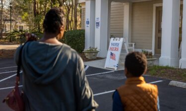 A woman walks with her son as she prepares to cast their ballot in the Democratic presidential primary at the Eastbridge Presbyterian Church in Mount Pleasant