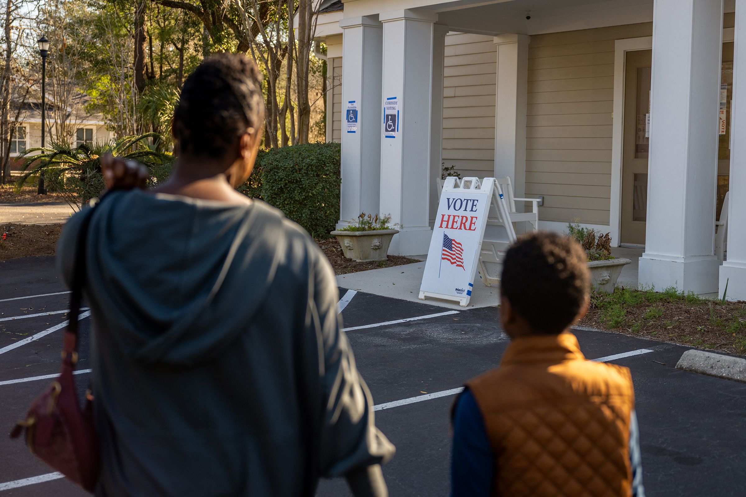 <i>Brandon Bell/Getty Images/File via CNN Newsource</i><br/>A woman walks with her son as she prepares to cast their ballot in the Democratic presidential primary at the Eastbridge Presbyterian Church in Mount Pleasant