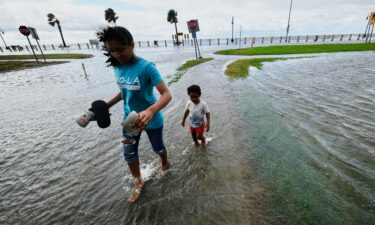 Residents walk in the floodwaters along Lake Pontchartrain in New Orleans as Tropical Storm Bertha approaches the Louisiana coast on Wednesday