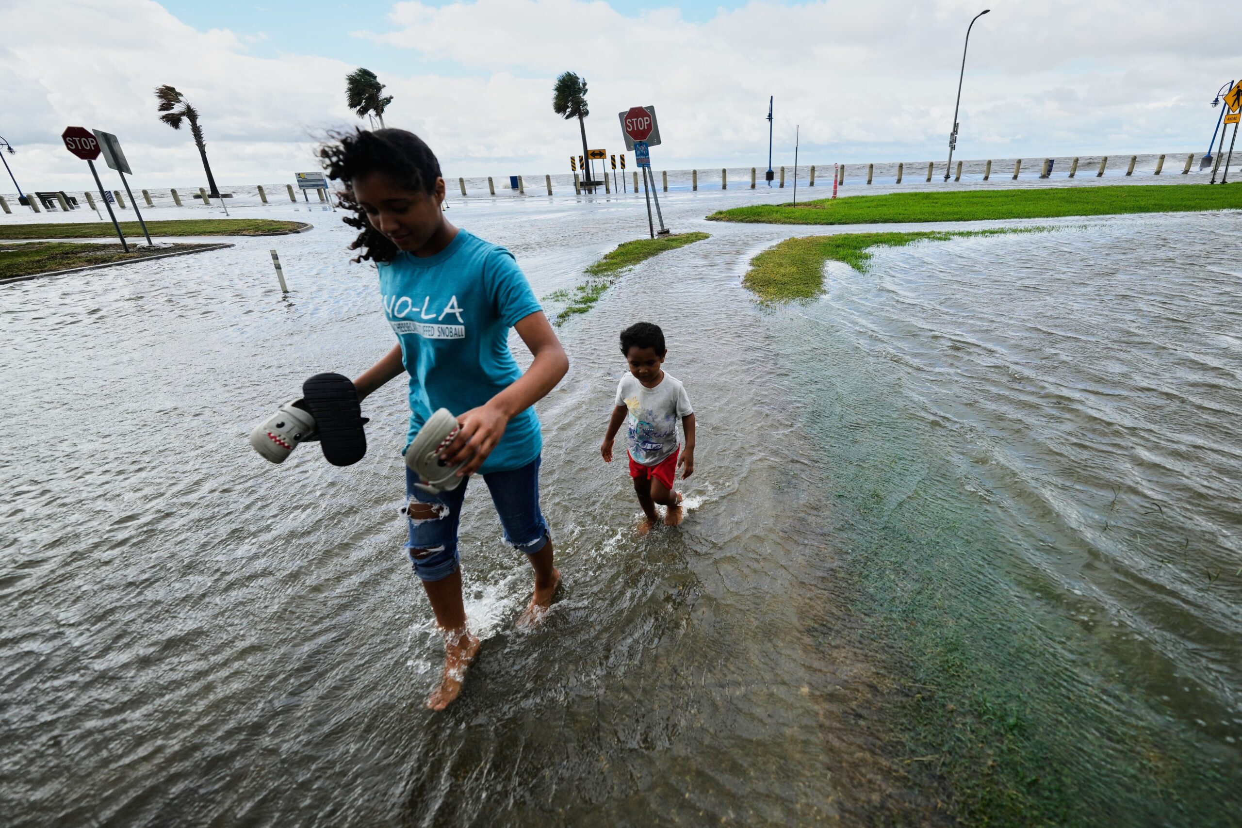 <i>Gerald Herbert/AP via CNN Newsource</i><br/>Residents walk in the floodwaters along Lake Pontchartrain in New Orleans as Tropical Storm Bertha approaches the Louisiana coast on Wednesday