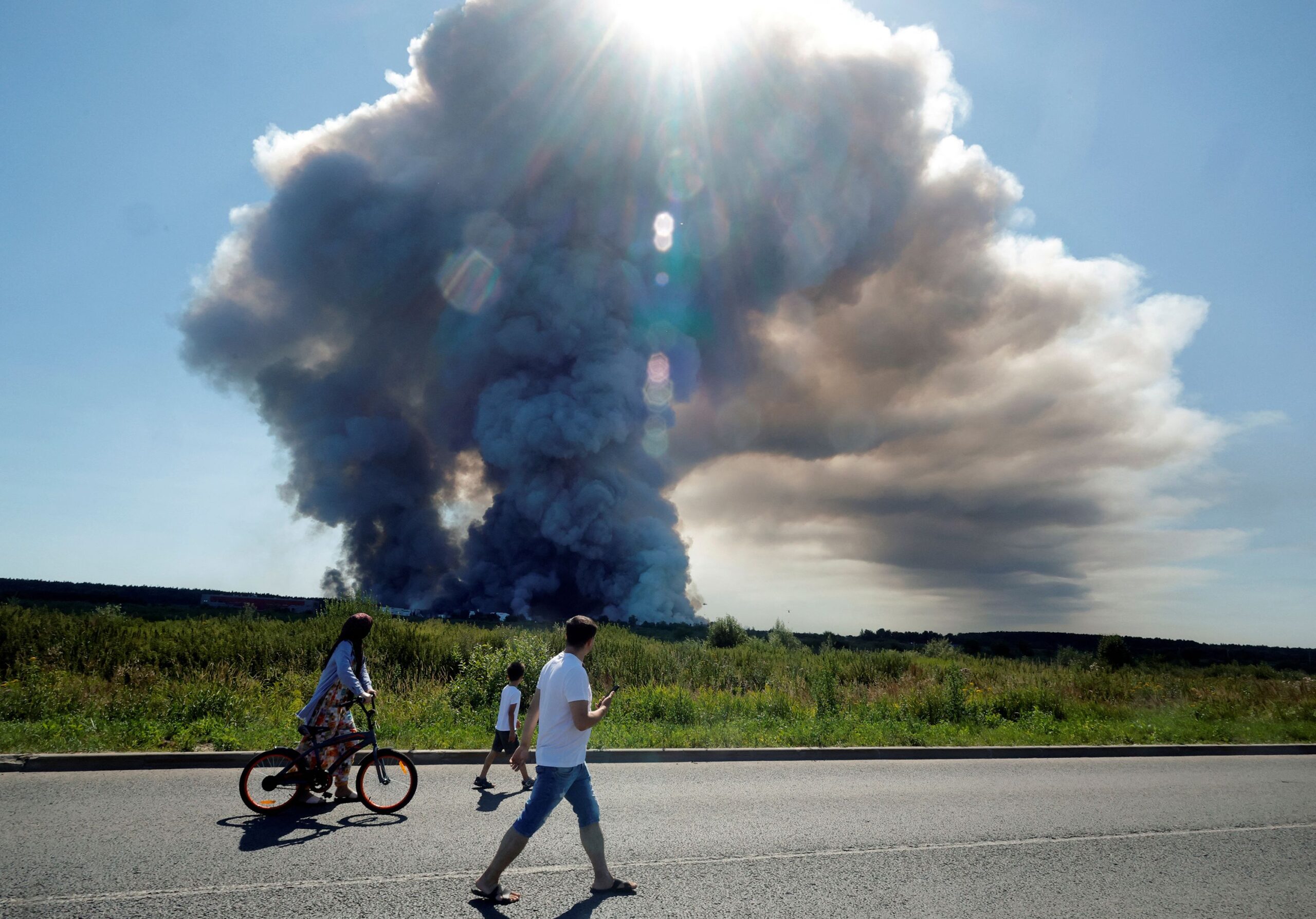 <i>Tatyana Makeyeva/AFP/Getty Images via CNN Newsource</i><br/>Local residents walk past the smoke of a fire at the Russian e-commerce firm Wildberries' logistics complexes in the town of Elektrostal outside Moscow on July 18.