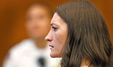 Lindsay Clancy watches as her ex-husband Patrick Clancy takes the witness stand on the first day of testimony in her triple-murder trial on Monday