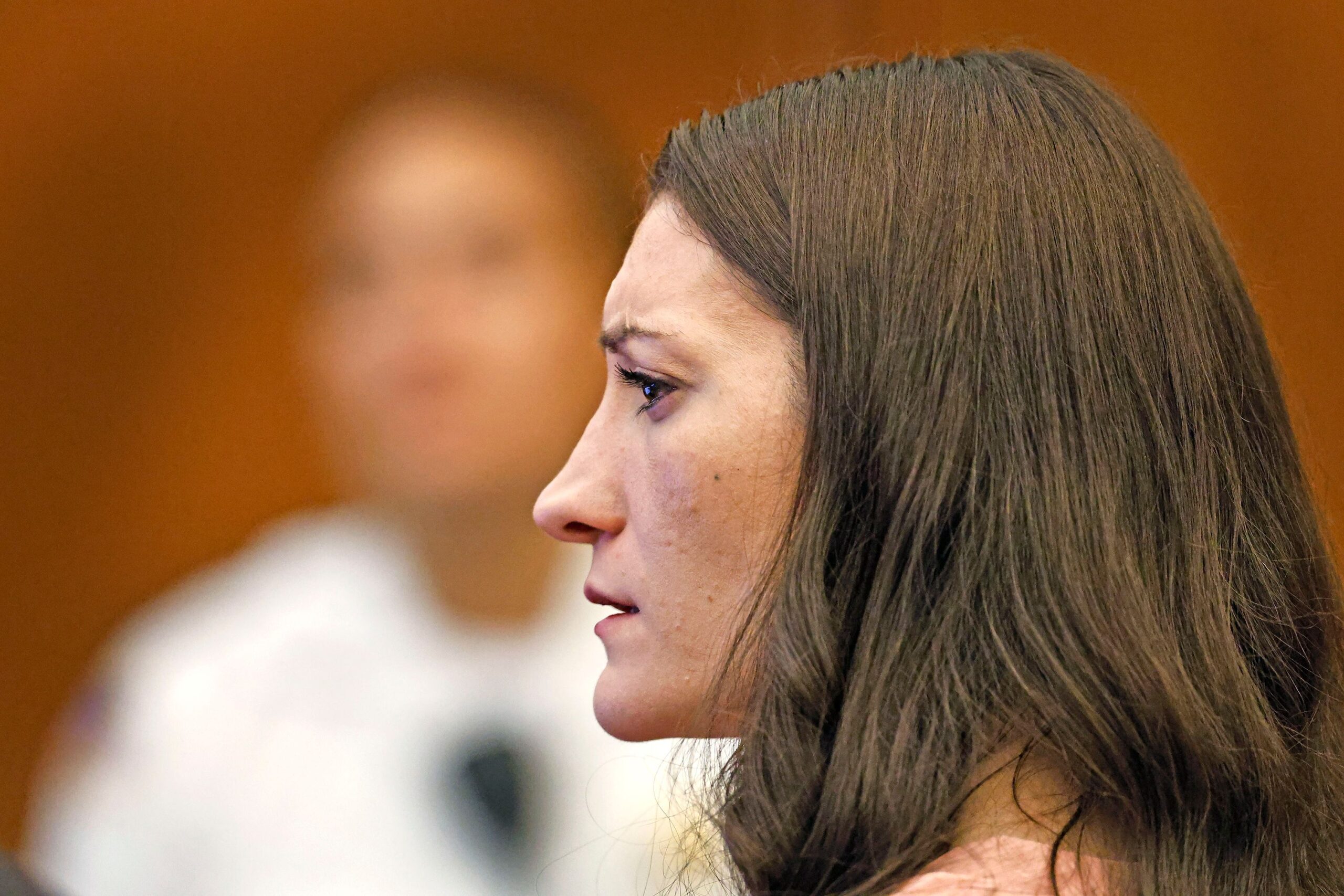 <i>Greg Derr/Pool/The Patriot Ledger via CNN Newsource</i><br/>Lindsay Clancy watches as her ex-husband Patrick Clancy takes the witness stand on the first day of testimony in her triple-murder trial on Monday