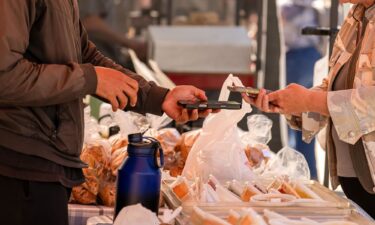 A shopper uses a smartphone to pay for produce during a farmers market at the Ferry Building in San Francisco on July 16.