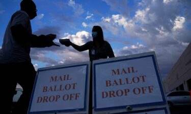 A county worker collects a mail-in ballots in a drive-thru mail-in ballot drop off area at the Clark County Election Department