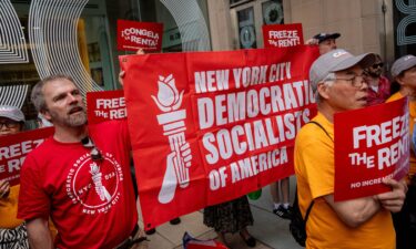 Demonstrators hold a "Democratic Socialists of America" banner ahead of a vote by the Rent Guidelines Board at El Museo del Barrio in New York