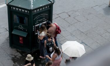 People line up to refill their water bottles at a public water dispenser near the Colosseum in Rome on July 4.