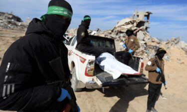 Palestinian Hamas and Islamic Jihad militants recover a body at a site as Hamas says it continues to search for the bodies of deceased hostages