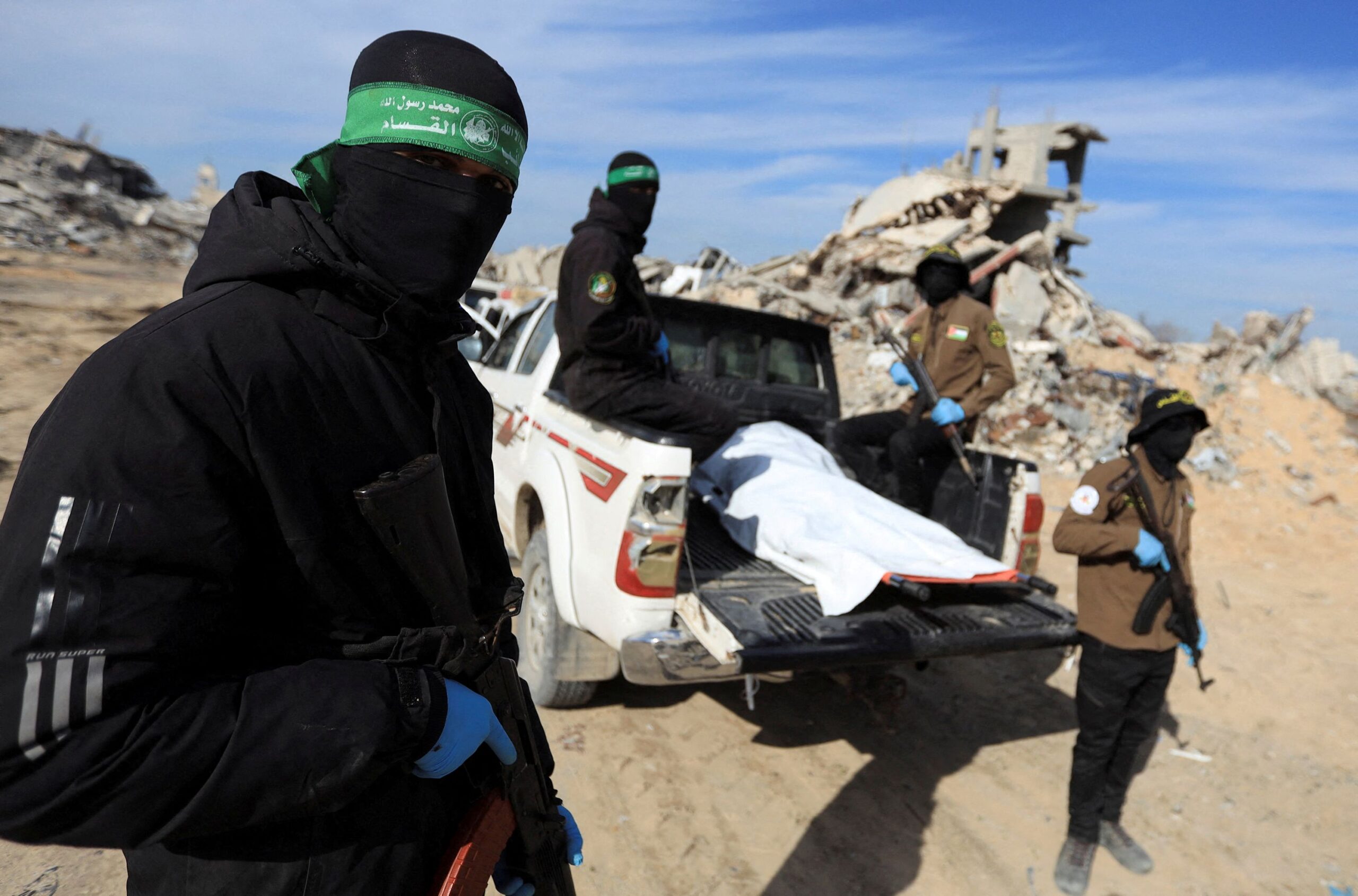<i>Stringer/Reuters via CNN Newsource</i><br/>Palestinian Hamas and Islamic Jihad militants recover a body at a site as Hamas says it continues to search for the bodies of deceased hostages