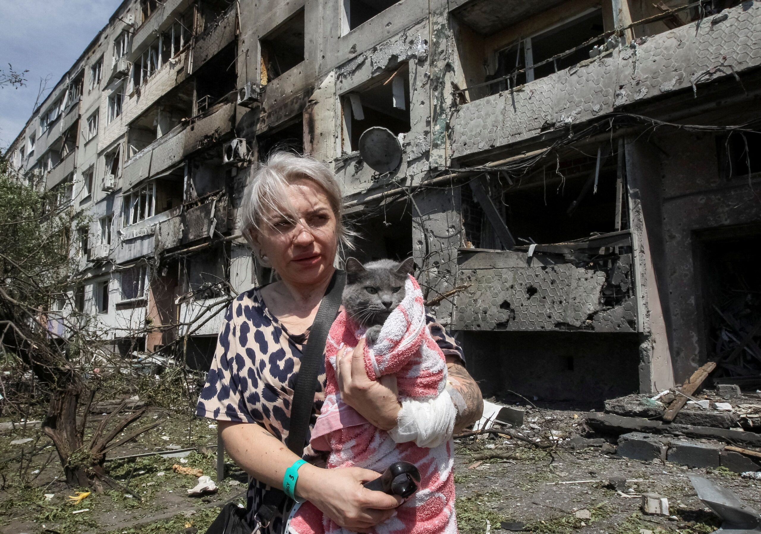 <i>Stringer/Reuters via CNN Newsource</i><br/>A woman with her cat stands near an apartment building hit by a Russian airstrike in the town of Pavlohrad in eastern Ukraine on July 20.
