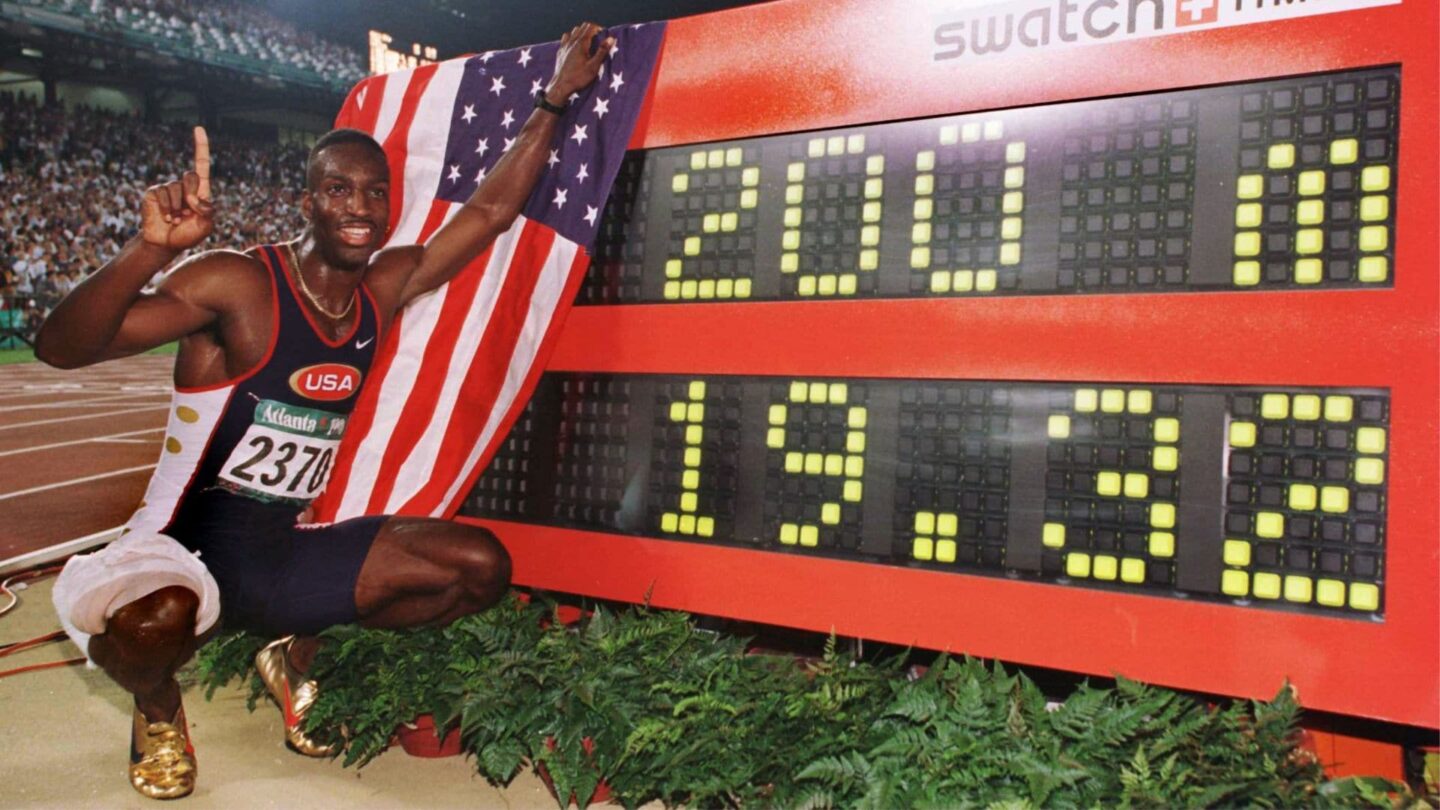 <i>NBC Olympics</i><br/>Michael Johnson celebrates by the timing board after setting the world record in the men's 200m at the 1996 Atlanta Summer Olympics.