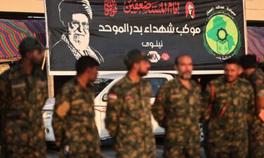 Members of Iraq's Popular Mobilization Forces stand near a portrait of Iran's slain supreme leader Ali Khamenei at the shrine of Imam Hussein on the eve of his funeral ceremonies in the holy Iraqi city of Karbala on July 7.
