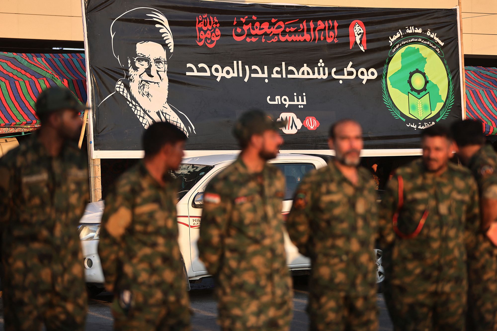 <i>Ahmad Al-Rubaye/AFP/Getty Images via CNN Newsource</i><br/>Members of Iraq's Popular Mobilization Forces stand near a portrait of Iran's slain supreme leader Ali Khamenei at the shrine of Imam Hussein on the eve of his funeral ceremonies in the holy Iraqi city of Karbala on July 7.